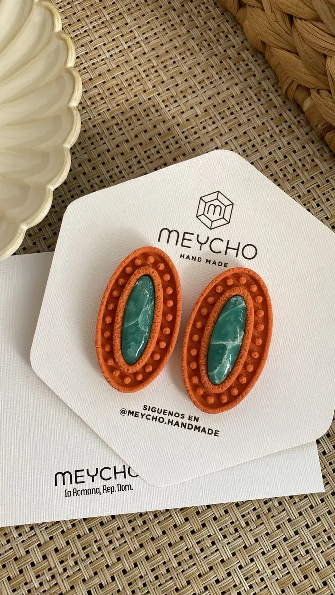 Aretes Itabo: óvalos naranja con centro turquesa, en su tarjeta